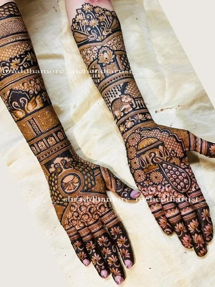 This design is a celebration of traditional Indian motifs. It includes a wedding palanquin (doli), elephants, swans, and peacocks, all woven together in a rich tapestry of henna.