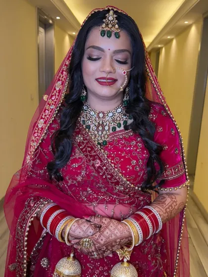 The soft glam on the eyes perfectly balances the bold red lip and traditional attire. This look is all about enhancing her features while keeping the focus on her.