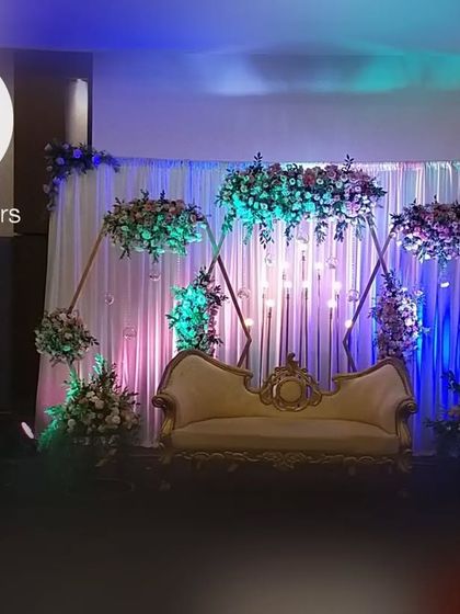 The complete anniversary party stage, combining the geometric backdrop, floral designs, and personalized ladder detail into one cohesive and beautiful setting.