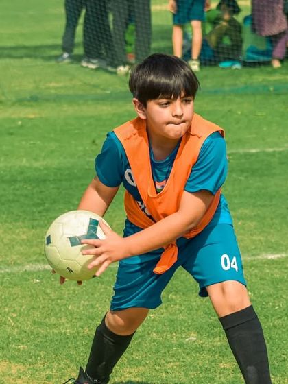 A young player prepares to throw the ball in from the sidelines.