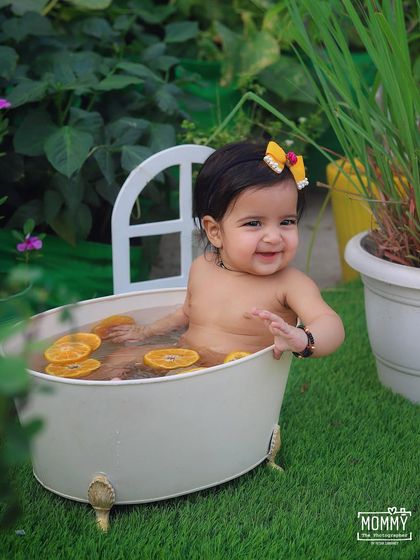 A refreshing orange-slice bath in the garden! This outdoor half-birthday session is a perfect way to cool down in the summer and capture some incredibly happy and splashy photos.