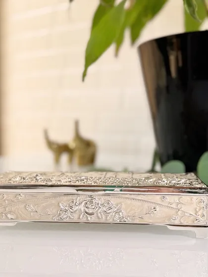 A side view of the pearl enamel jewellery box, highlighting the beautiful floral engraving that runs along its length. Every surface is a canvas for artistry.