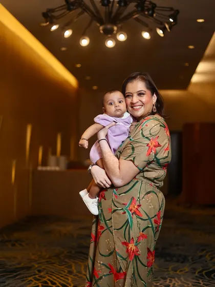 A mother holding her baby in a beautifully lit hallway. This is a simple, elegant portrait that focuses on the bond between them.