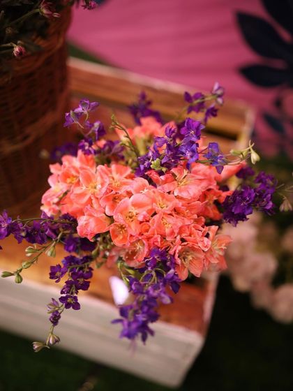 A close-up of a vibrant floral combination. The contrast between the bright orange and deep purple flowers creates a striking and beautiful detail in a larger arrangement.