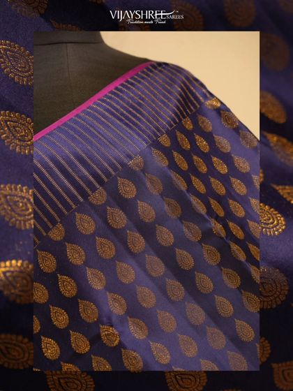 A close-up of the shimmering gold leaf buttas against the deep blue silk.