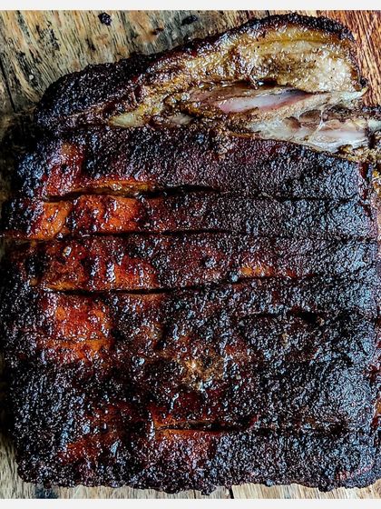A full rack of my signature Karnivore Ribs, celebrating one year of grilling. This version features a classic Indian spice rub, grilled low and slow for a perfect crust and tender meat.