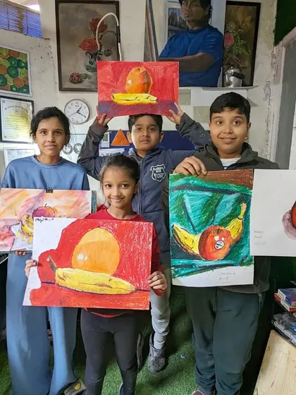 The results of a still life session with fruits. Our students proudly show their work, done in oil pastels and watercolors, each capturing the colors and forms in their own style.