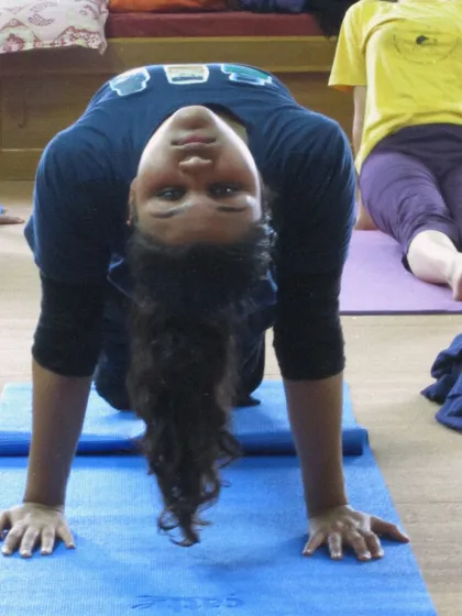 A student in a cat-cow stretch during a TTC class. Even simple movements are taught with an emphasis on breath and awareness.