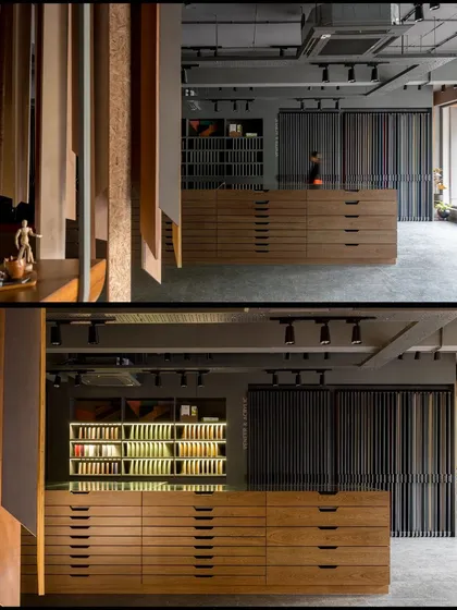 This central island serves as a display and storage unit, with large drawers for samples and a glass top for consultations. The lit interior of the drawers highlights the different material options.