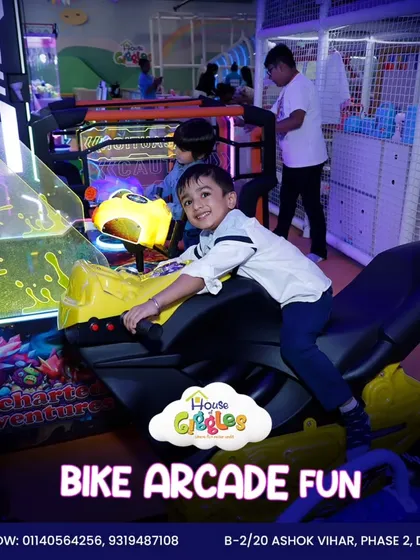 Pedal your way to fun on our bike arcade game! This little racer is having a blast, smiling for the camera while enjoying the thrill of a virtual ride.
