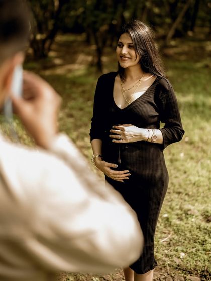 An over-the-shoulder shot of the mom-to-be, as if her partner is taking a photo of her. It’s a sweet, meta moment that feels very personal.