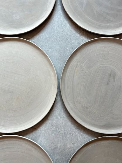 A satisfying view of perfectly uniform plates, made by one of our skilled potters, ready for the drying process.
