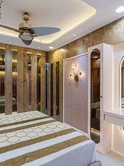 This bedroom in Seawoods combines rustic wood slats with a modern, backlit vanity mirror. The design plays with textures and light to create a visually interesting and highly functional personal space.
