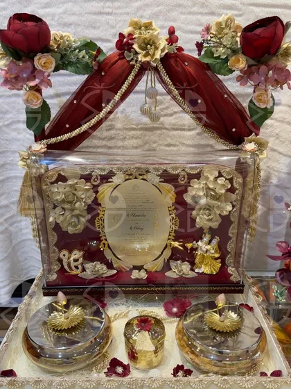 A grand wedding invitation hamper, designed in the shape of a doli. This piece includes the invitation itself, along with sweets and other small gifts, creating an unforgettable first impression.
