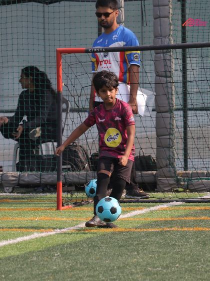 A young player sets up for a free-kick, focusing on technique and placement.
