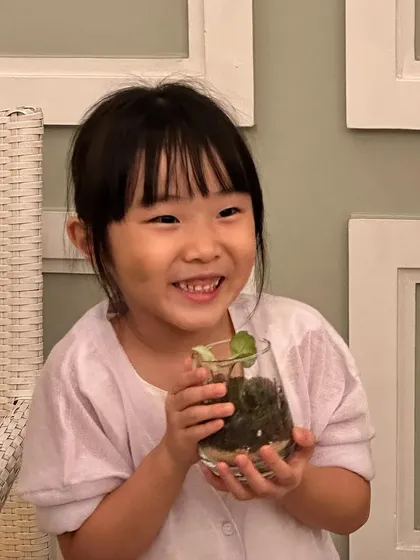 The joy of creating with nature is for everyone, no matter your age. This young participant's smile says it all. My workshops are a family-friendly activity, perfect for nurturing a love for plants in the next generation.