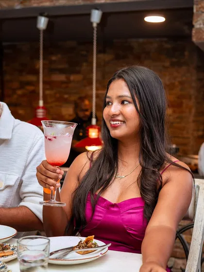 A guest raises her glass, her smile capturing the joyful spirit of our Sunday brunch.