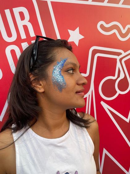 A side view of the blue glitter design, showing how it sweeps up from the cheekbone.