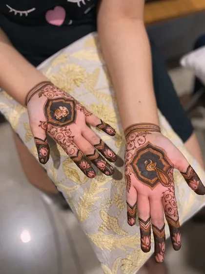 A luxurious and modern design. The central motifs with peacock details are framed by simple, elegant finger patterns.