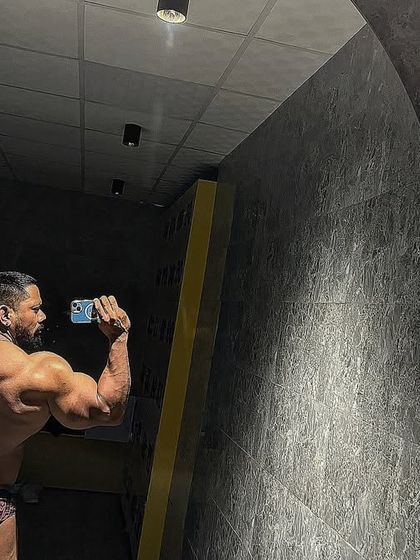Back double bicep pose in the mirror. Determined to win.