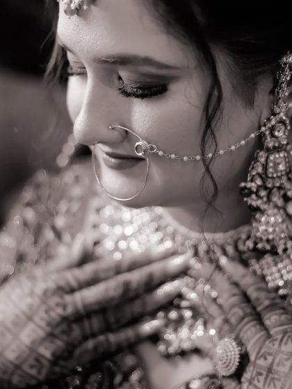 A touching black and white bridal portrait. The bride's expression is full of emotion, and the monochrome tones emphasize the heartfelt moment and the intricate details of her jewelry.