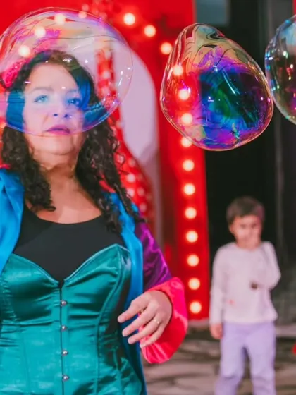 A close-up of the bubble show, capturing the iridescent colors of the bubbles and the performer's focused expression. It’s a moment of simple, beautiful magic that adds so much to the party's atmosphere.