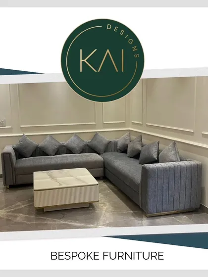 This grey L-shaped sectional sofa is paired with a contemporary coffee table featuring a marble top and a fluted base. The combination of textures and clean lines creates a sophisticated and comfortable living area.