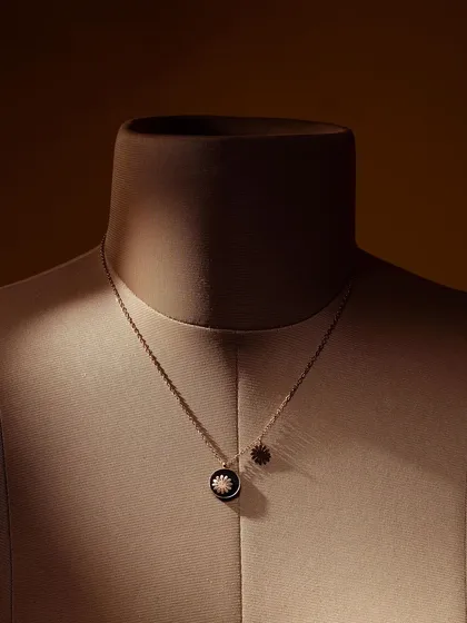 A minimalist shot of a necklace on a mannequin bust. This classic display method, enhanced by moody lighting, gives the product a timeless and elegant feel, perfect for catalogues.
