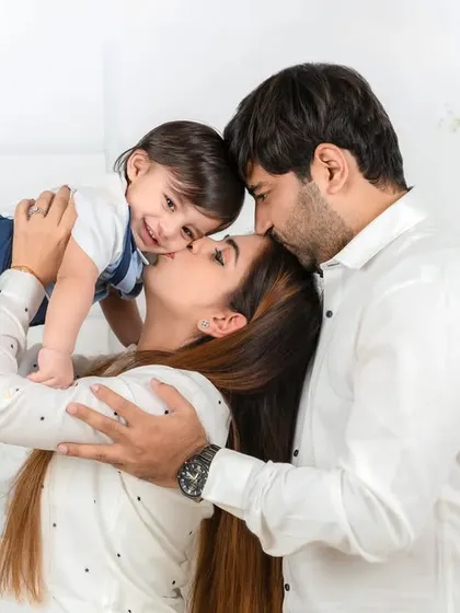 A tender, candid moment capturing the pure love of a family. A mother and father gently kiss their baby, creating a memory of warmth and connection that will last forever.