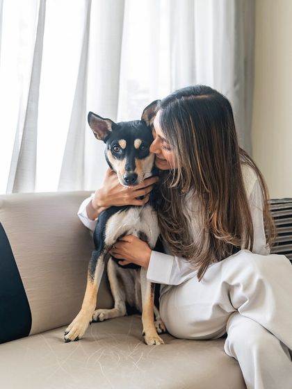 A warm embrace between Luna the Indie and her mom on the couch. The soft lighting and genuine smiles make this a perfect example of a relaxed, lifestyle family portrait.