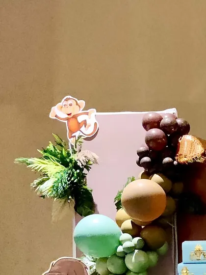 A detail shot of the balloon arch with a monkey cutout and tropical leaf accents.