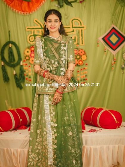 The bride stands gracefully, crossing her arms to show the full extent of her beautiful henna design.