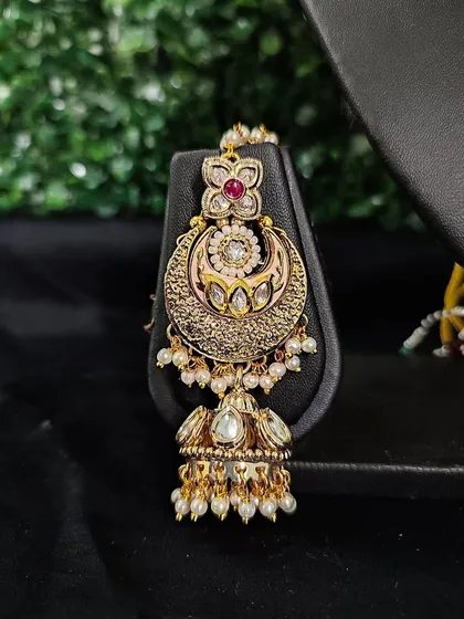 The matching passa from this set, designed to be worn on the side of the head for a complete, regal bridal look.
