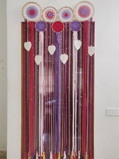 A full view of the custom macrame curtain we created. The colorful strands hang beautifully, creating a unique and artistic partition for a doorway.