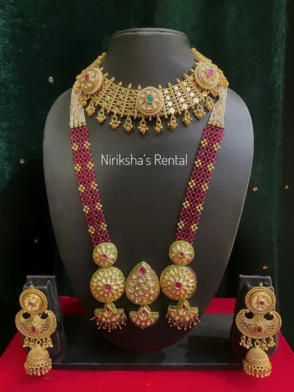 A striking jewellery set featuring maroon beads and large pendants. This is a bold, statement piece available for rent.