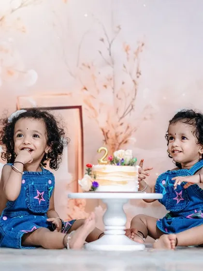 We specialize in capturing the unique bond of twins. This studio session for a second birthday celebration uses a soft, dreamy backdrop to highlight their adorable interaction and individual personalities.