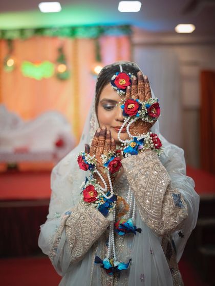 A creative portrait of the bride showcasing her floral jewellery during her Mehendi ceremony. This highlights the beautiful, artistic details of her look.