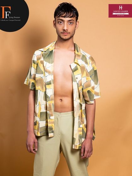A full-length shot of the male model, showing how subtle makeup and grooming contribute to a professional, high-fashion look.