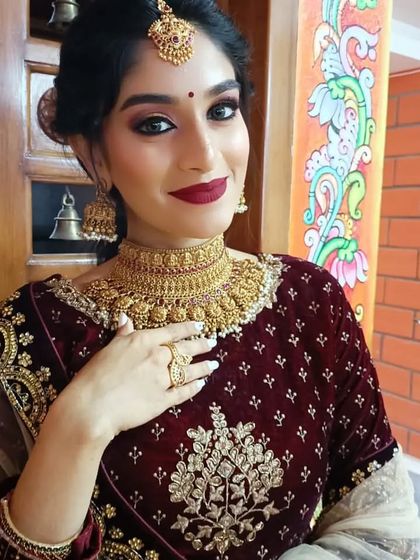 A model in a deep red velvet lehenga, adorned with our antique gold choker and jhumkas. A perfect look for a North Indian style wedding or reception.