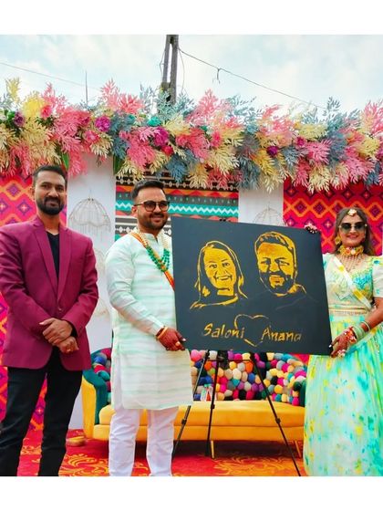 Presenting the finished glitter portrait to the happy couple at their wedding event in Saputara. Their smiles make all the hard work worth it. This is a unique wedding gift that lasts a lifetime.