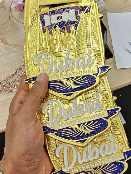 A close-up of the three gold medals my client won at the ICN Dubai show. She competed and won in the Bikini Fitness, Swimsuit, and Transformation categories.