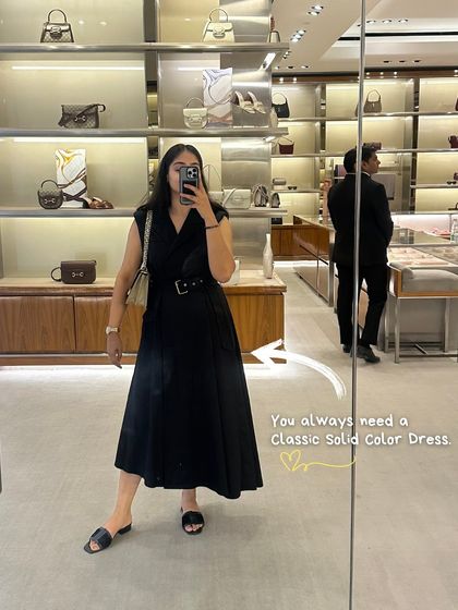 Another style lesson: you always need a classic solid color dress in your wardrobe. It's a versatile piece that can be dressed up or down for any occasion, like this black dress I'm wearing while browsing a luxury store.