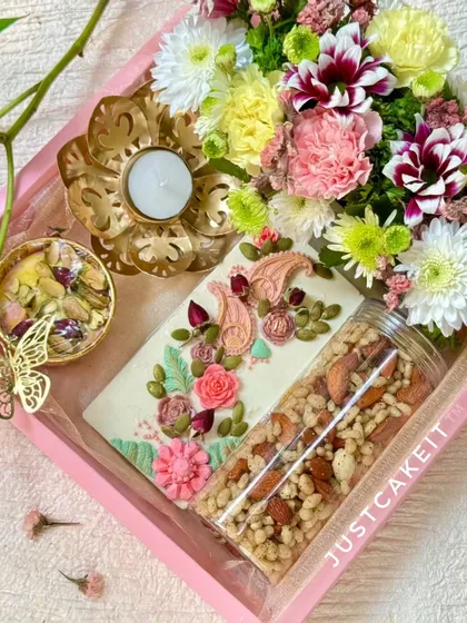 My artisanal gift hampers are perfect for any festival or special occasion. This 'Festive Bloom' Diwali hamper combines hand-painted white chocolate, a savory crunch mix, and fresh flowers for a truly elegant gift.