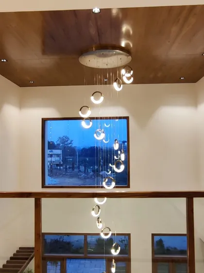 For this double-height living area, I installed a cascading spiral chandelier to make a grand statement. This type of lighting fixture adds a touch of modern elegance and draws the eye upward, emphasizing the scale of the room.