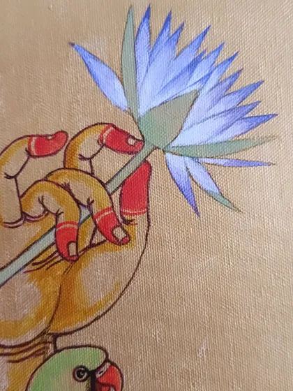 A close-up of the "PoornaChandrika" painting in progress, focusing on the hand of Kamakshi holding a blue lotus. This detail highlights the delicate line work and the layering of color on canvas, a process that requires immense patience and faith from both the artist and the client.