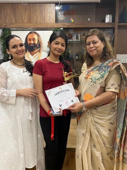 Another proud member of the winning "Yogini" team receiving her certificate and trophy. Her smile reflects the supportive and encouraging environment we foster.