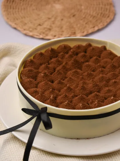 Make way for our Tiramisu, and the best part is, it's eggless. This classic Italian dessert features layers of coffee-soaked sponge and creamy mascarpone, dusted with cocoa powder and presented in an elegant cake ring.