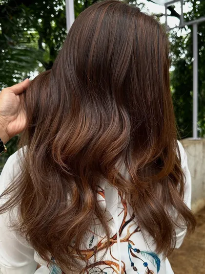 Getting ready for 'Ghar ki shaadi' (a home wedding). This client wanted a glamorous but natural look, so I gave her a rich color melt with soft waves, perfect for the occasion.