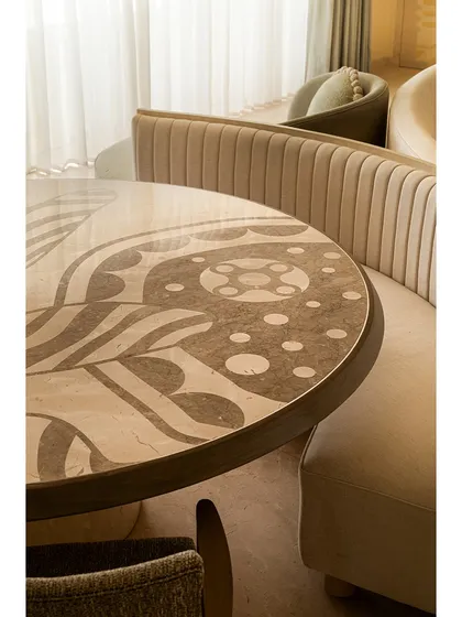 We see dining tables as centerpieces for stories and meals. This piece features a custom marble inlay top with sinuous patterns inspired by illustrator Jane Foster, crafted from Crema Marfil and Federal Beige marble. It’s paired with a fluted banquette, creating an intimate and artistic dining nook.