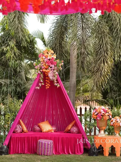 A cozy and colorful seating nook for a Mehndi. I used a vibrant pink tented structure and plush cushions to create an intimate space for guests to relax and get their henna done.